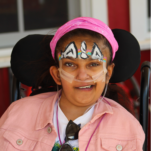 Young camper in wheelchair smiling at camera