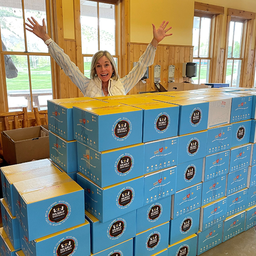 Joy, delivered boxes with volunteer with hands up