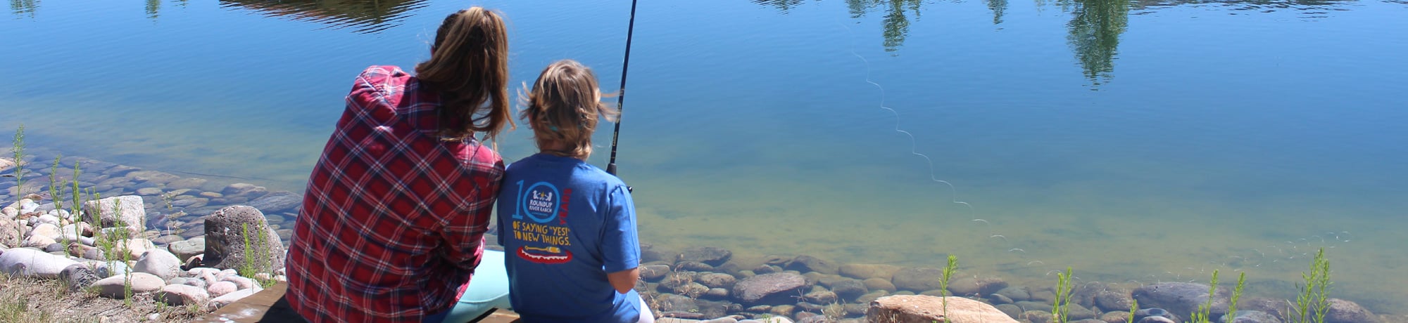nurse and camper fishing at pond