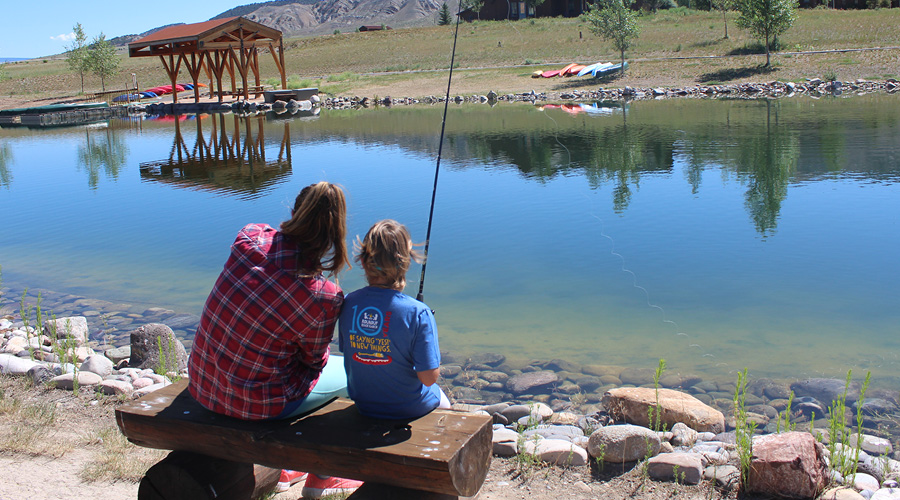 nurse and camper fishing at pond