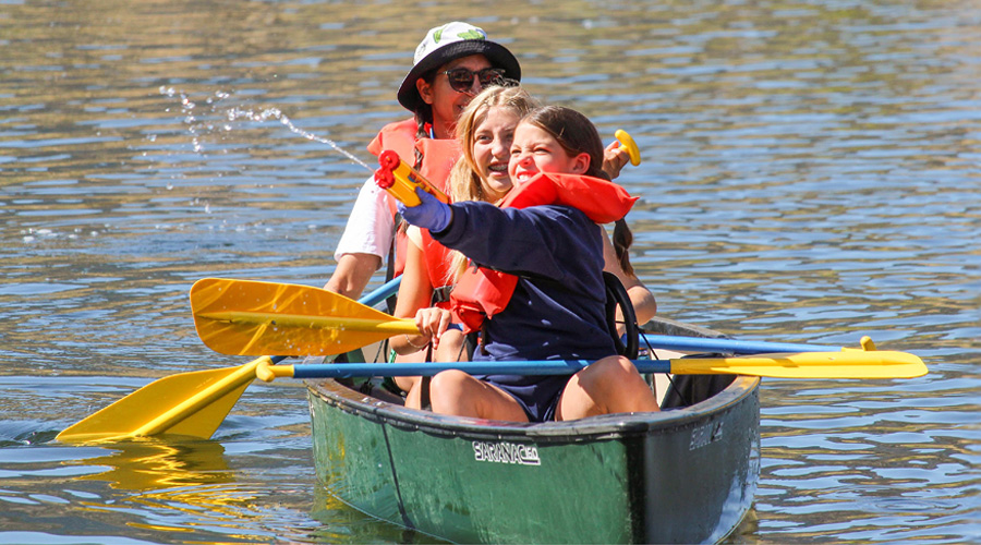 campers in canoe shooting squirt guns