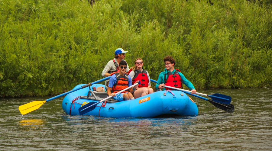 Spur program campers in a raft on the river.
