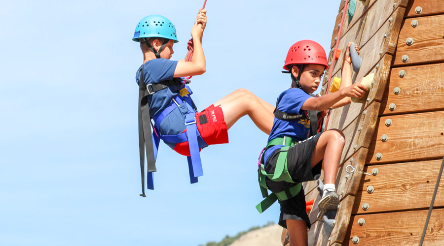 Two children ascending the climbing wall