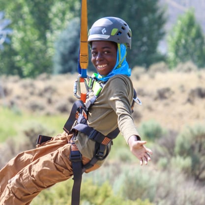 camper smiling riding the zip line.